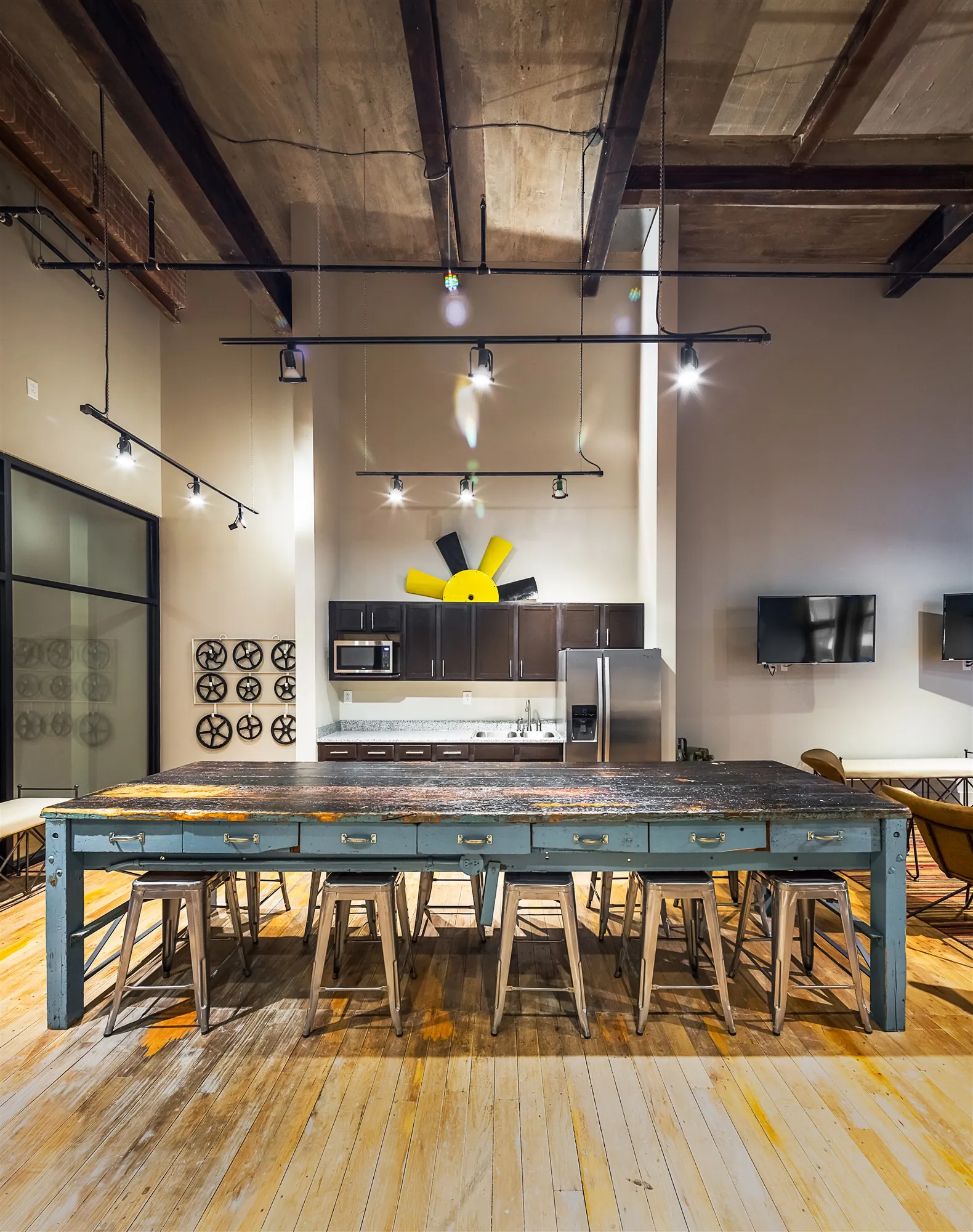 Long reclaimed-wood community table in the Weaving community room at Drayton Mills Lofts