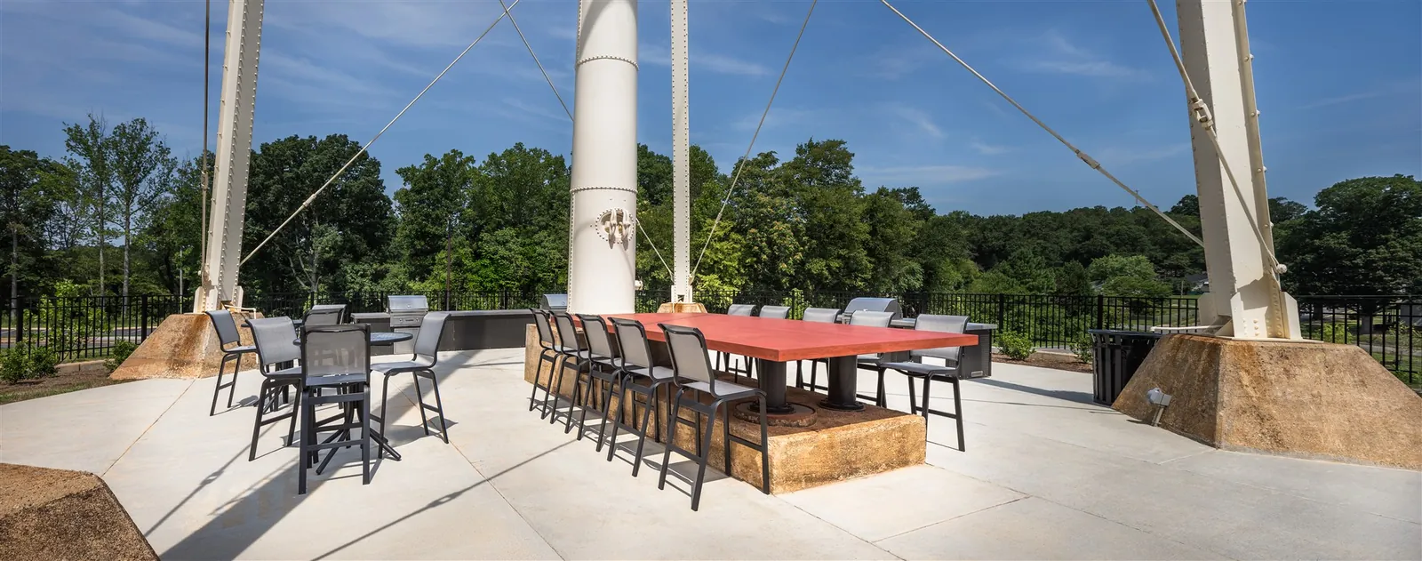 Outdoor dining tables and grills beneath the water tower at Drayton Mills Lofts