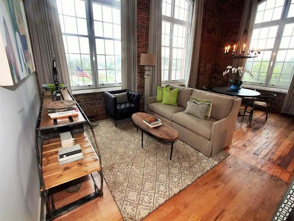 Loft kitchen with island and chandelier opening to the living area at Drayton Mills Lofts