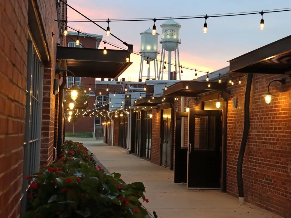 String lights over the Drayton Mills Marketplace walkway at dusk