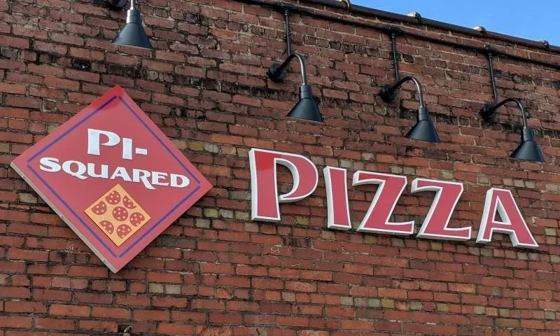 Pi-Squared Pizza sign on the brick wall of the Drayton Mills Marketplace