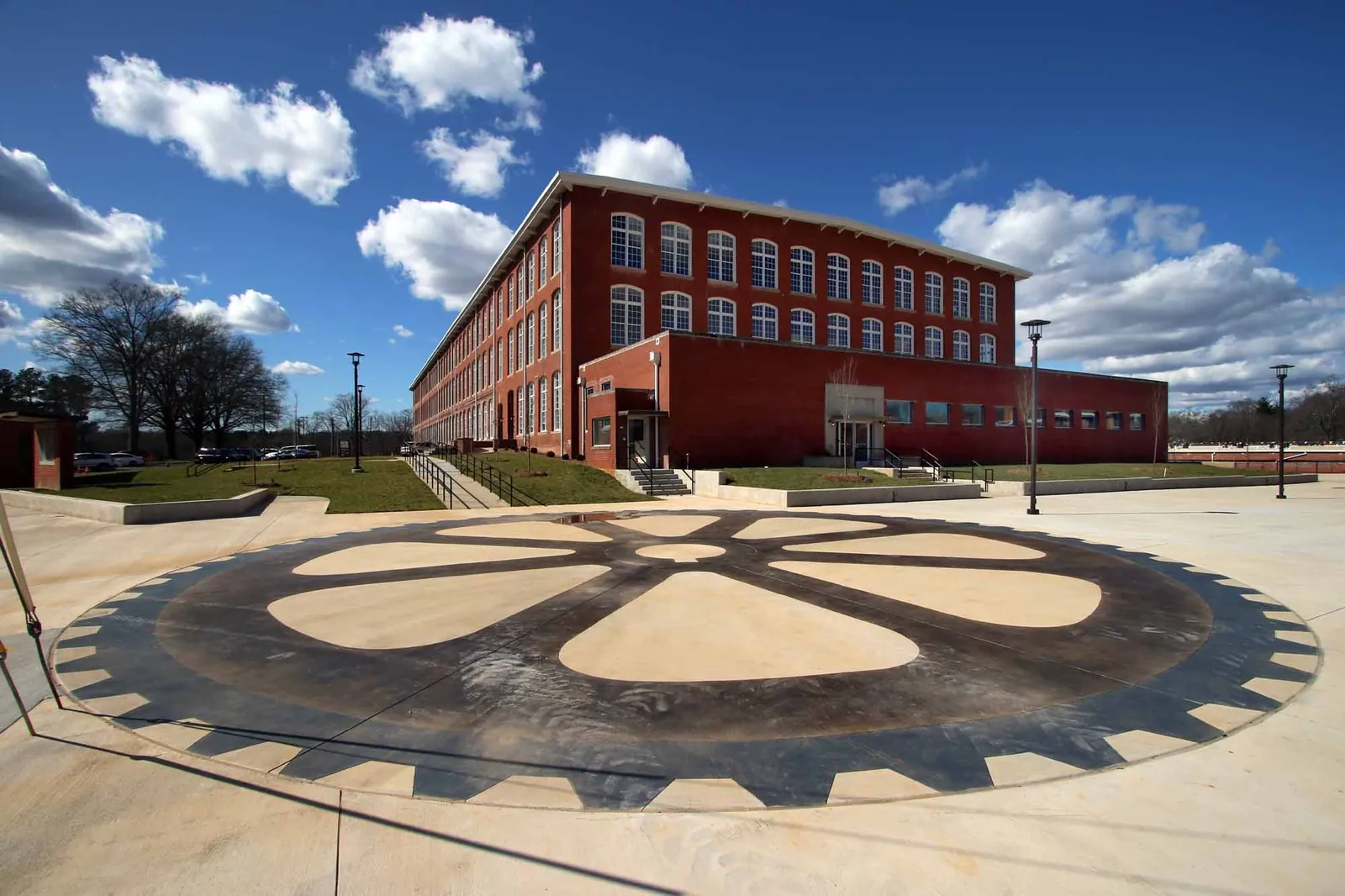 The entry plaza with its gear-pattern paving at Drayton Mills Lofts