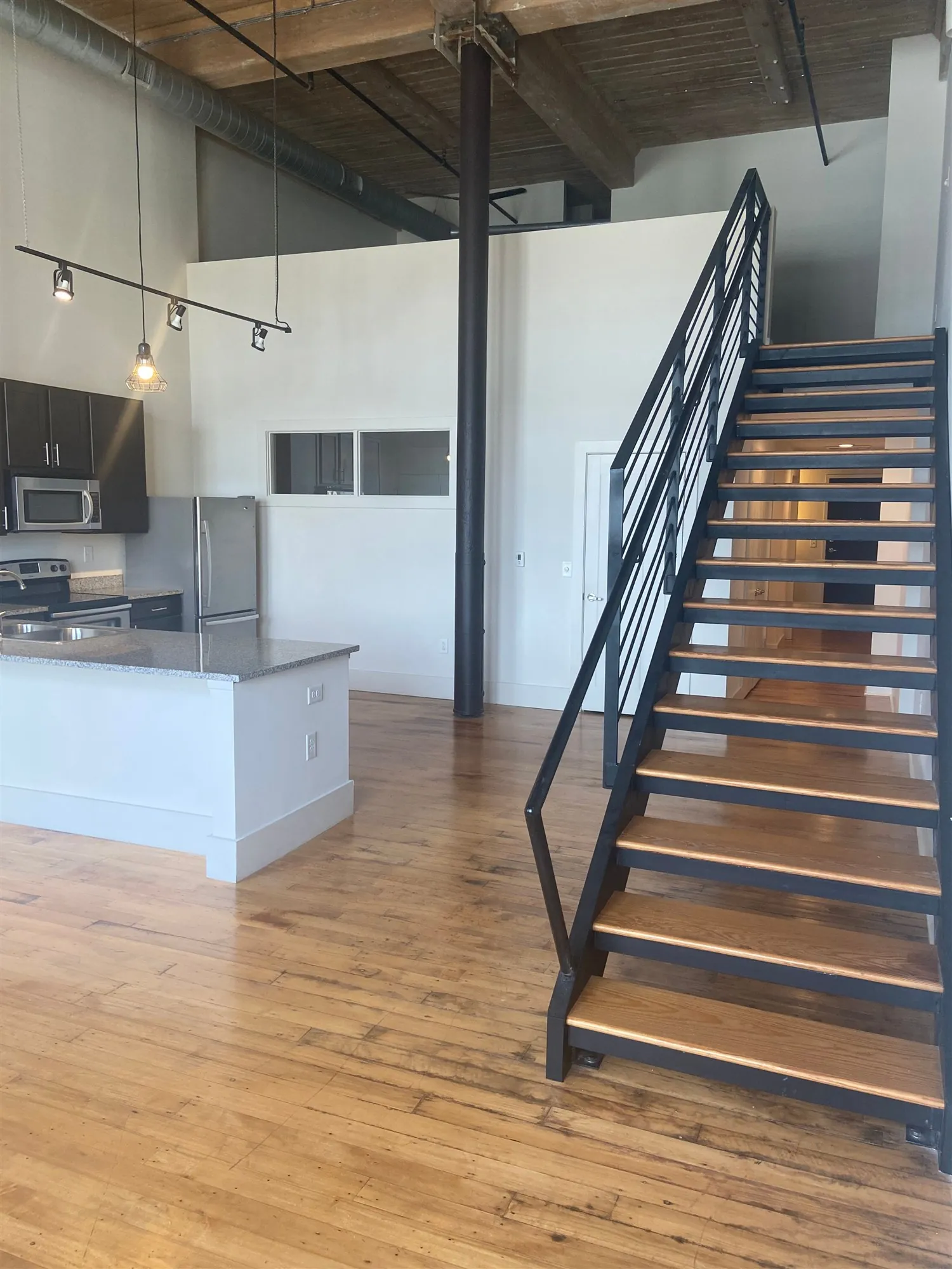 Steel staircase and kitchen island in a two bedroom loft at Drayton Mills Lofts