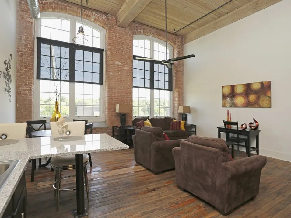 Loft living room with 17-foot ceilings and original hardwood at Drayton Mills Lofts